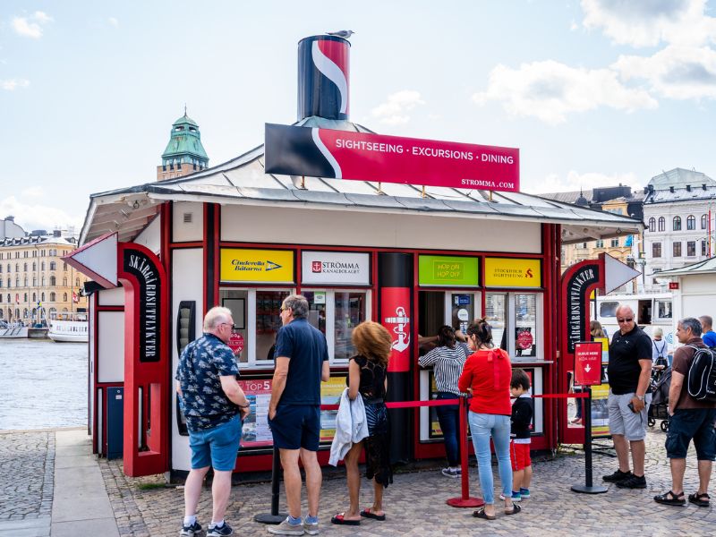 Touristen am Ticketschalter für eine Bootstour in Stockholm