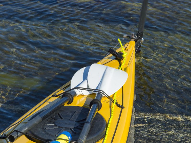 Kajak mit Paddeln festgemacht am Ufer im Wasser